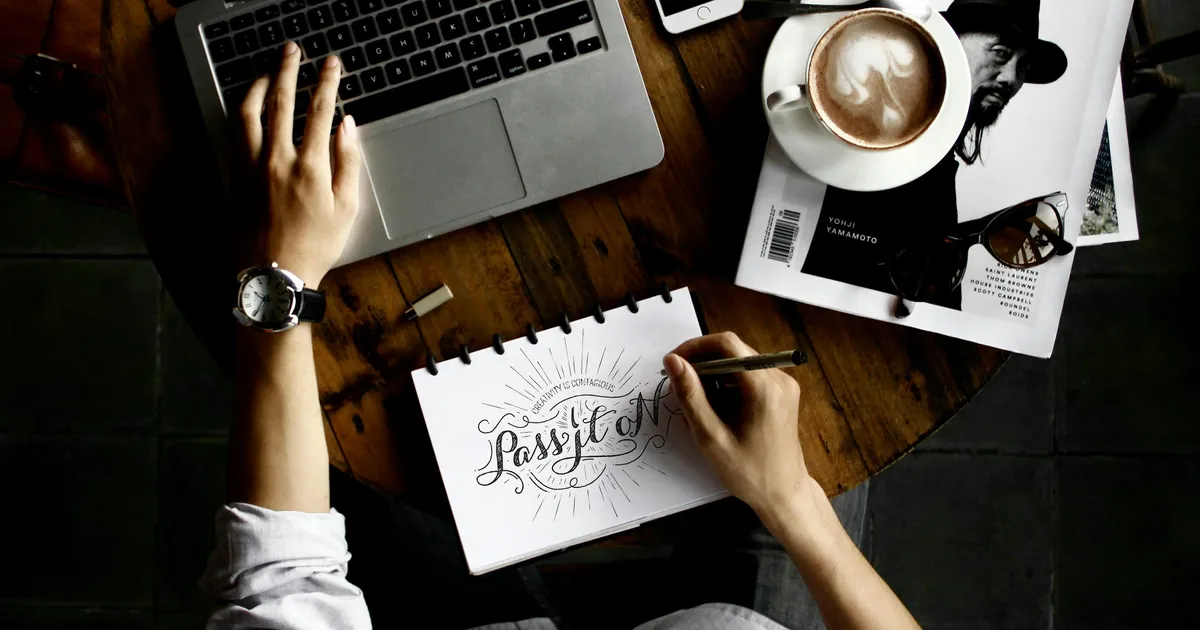 Laptop mit geöffneter Website und Designentwurf auf dem Tisch