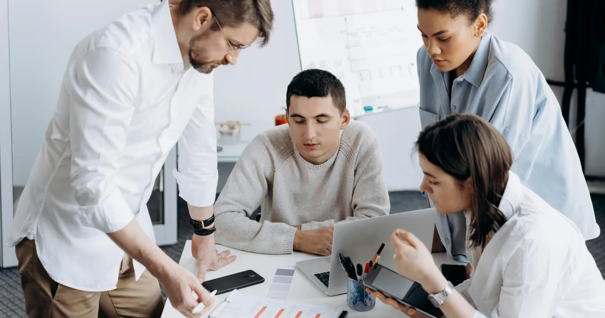 Ein kleines Team arbeitet gemeinsam an einem digitalen Projekt